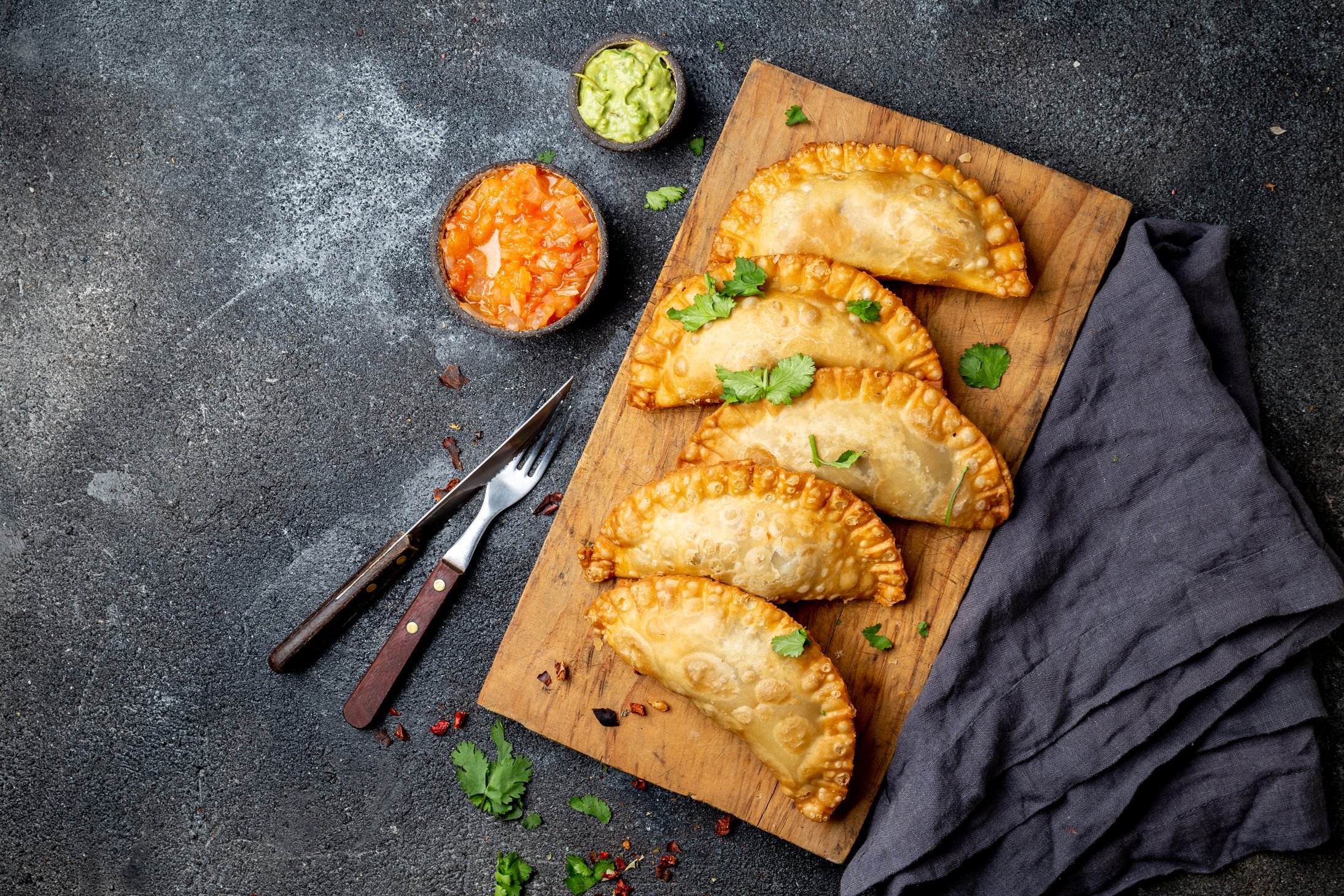 Latin American Fried Empanadas with Tomato and Avocado Sauces. Top View